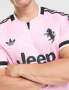 Dettaglio stemma e pattern zebrato della maglia Juventus Away 2026/2027 adidas rosa