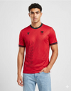 Maglia Albania Home 2026 Macron rossa con pattern a onde scure e stemma FSHF aquila bicipite indossata da modello