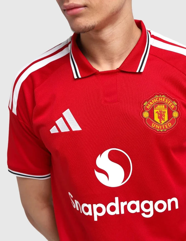Manchester United maglia home 2026/2027 Adidas rossa con colletto polo bianco-nero tre bande e sponsor Snapdragon