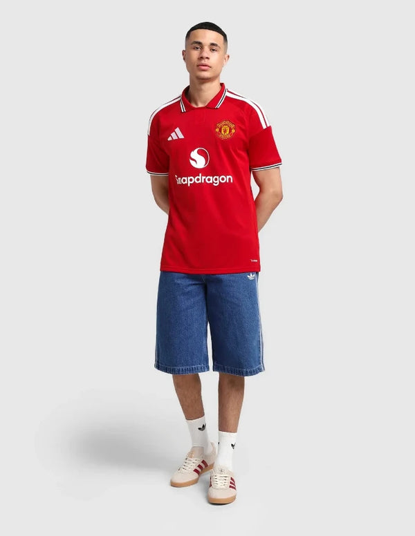 Manchester United maglia home 2026/2027 Adidas vista completa con jeans e sneaker