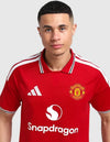 Dettaglio stemma Manchester United maglia home 2026/2027 Adidas con diavolo rosso e sponsor Snapdragon bianco