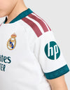 Dettaglio sponsor HP e strisce Adidas bordeaux sulla maglia Real Madrid Home Bambino 2026/2027