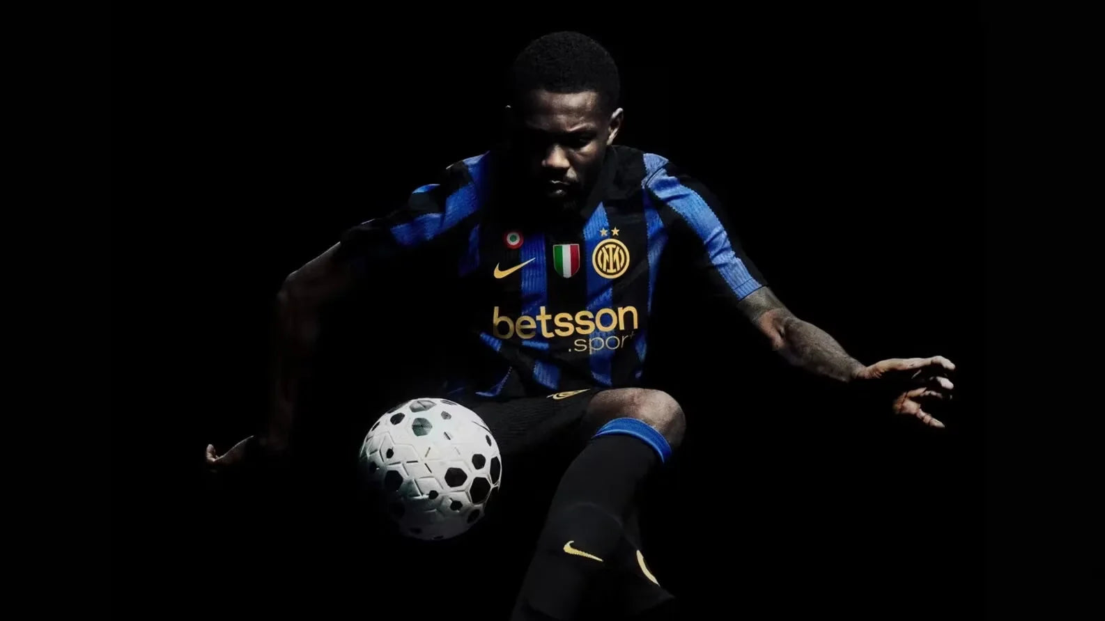 Inter Maglia Home 2026/2027 Nike reveal ufficiale - giocatore in azione con pallone su sfondo nero