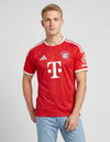 Bayern Monaco maglia home 2026/2027 Adidas rossa con righe verticali tono su tono tre bande bianche e sponsor Deutsche Telekom