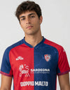 Dettaglio Cagliari maglia home 2025/2026 ETE con stemma Cagliari Calcio e pattern grafico sul pannello blu