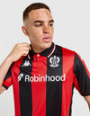 Nizza Maglia Home 2025/2026 indossata da un modello con strisce verticali rosse e nere, logo OGC Nice e sponsor Robinhood.