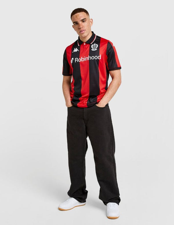 Nizza Maglia Home 2025/2026 indossata da un modello, con strisce rosse e nere, logo OGC Nice e sponsor Robinhood.
