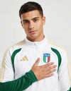 Primo piano Tuta Drill Italia 2026 bianca con logo Adidas oro e stemma FIGC.
