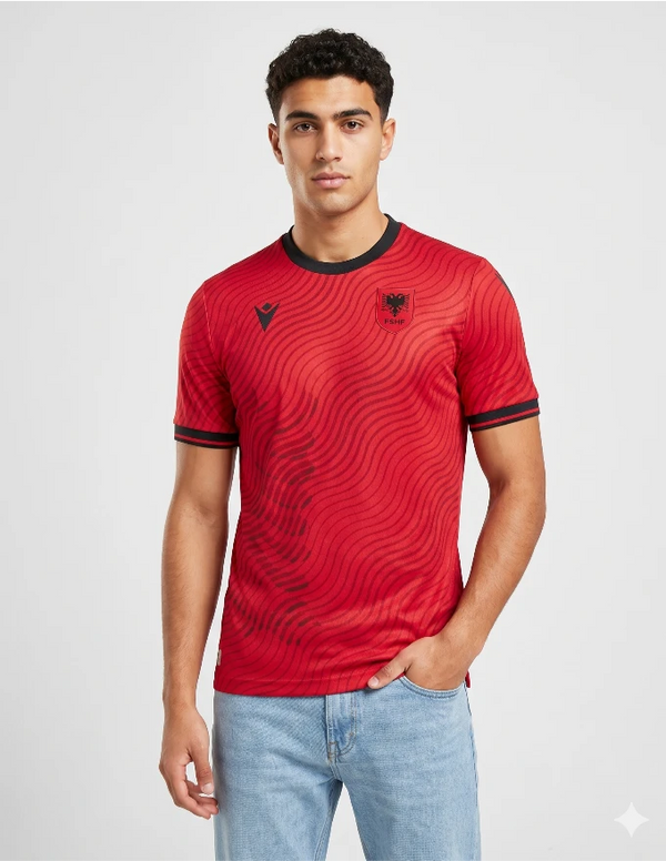 Maglia Albania Home 2026 Macron rossa con pattern a onde scure e stemma FSHF aquila bicipite indossata da modello