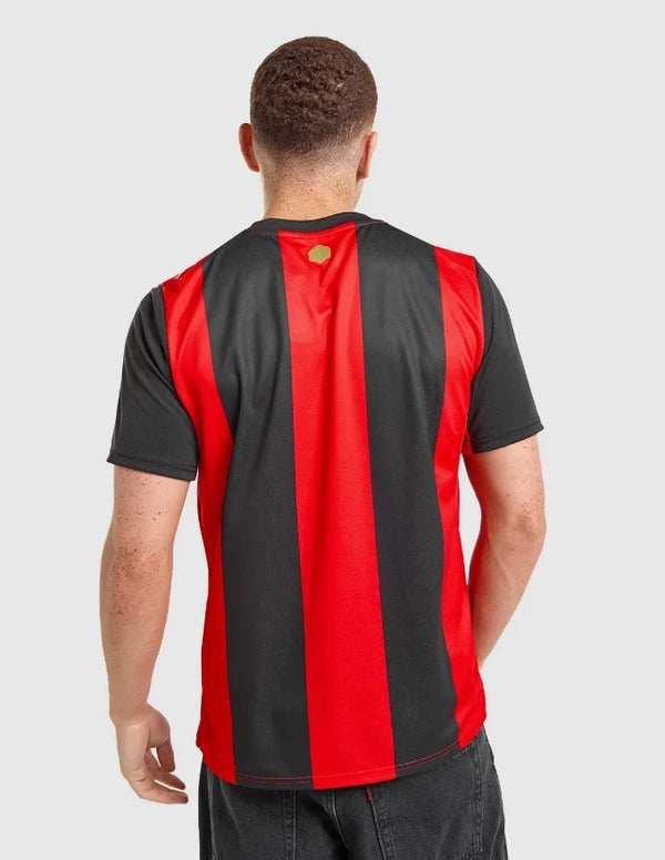Milan Maglia Home 2026/2027 Puma vista posteriore con striscia rossa centrale e badge oro