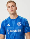 Dettaglio Schalke 04 maglia home 2026/2027 Adidas con stemma S04 e tre bande azzurro cielo sulle spalle